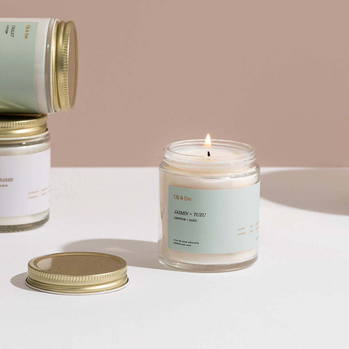 Candle with a label and packaging on a neutral background