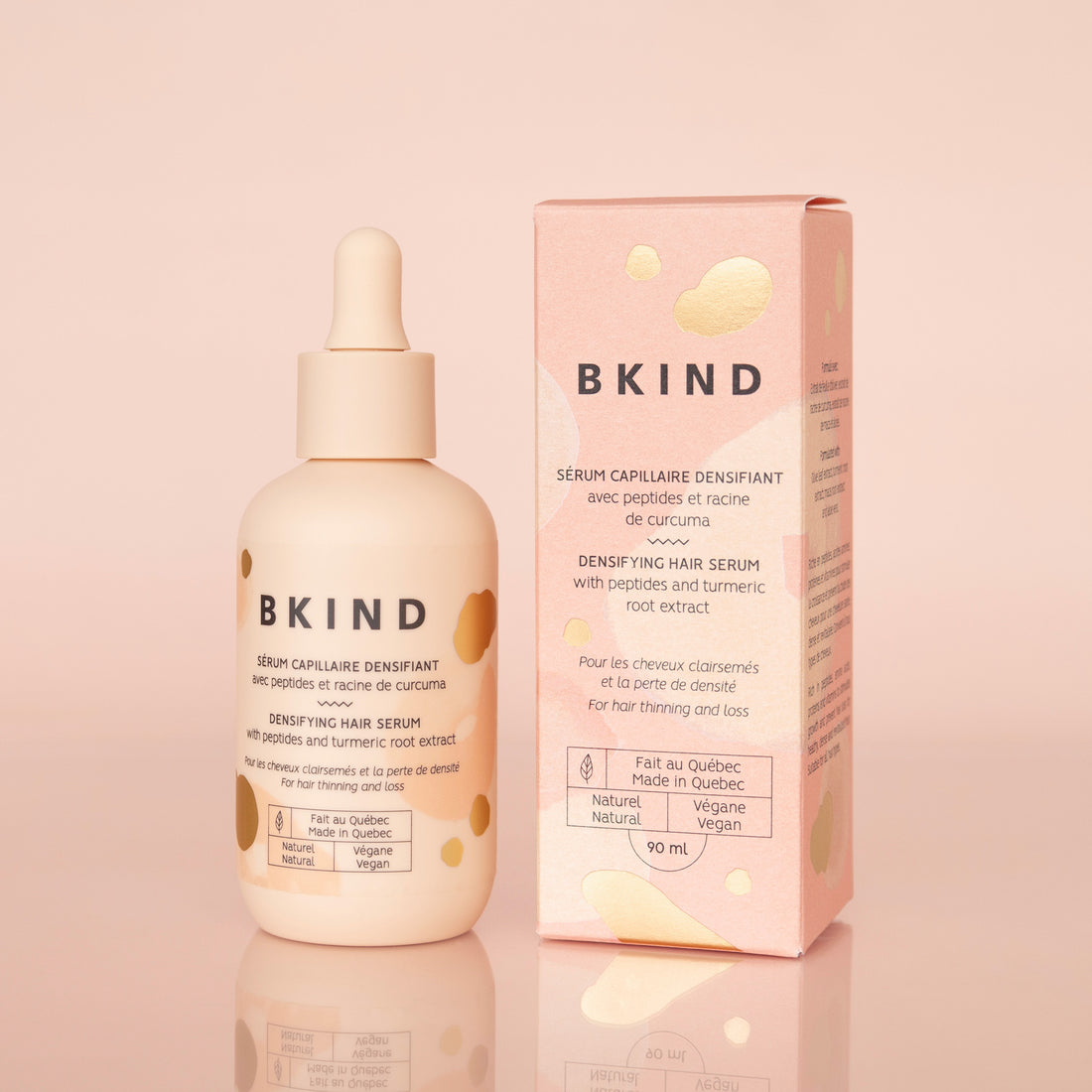 BKIND hair serum bottle and packaging on a pink background