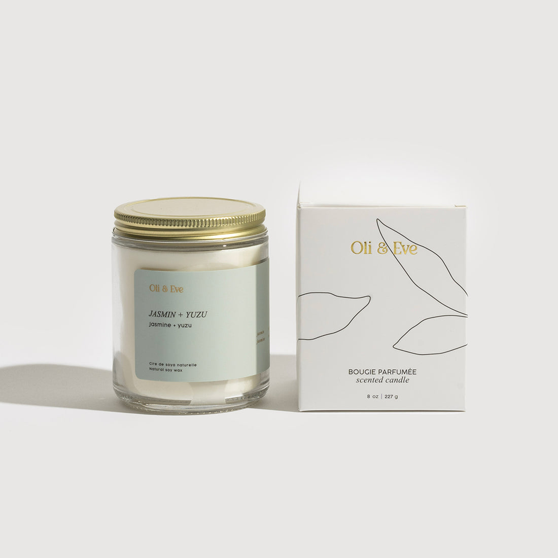 Candle with gold lid and Oli & Eve box on a white background