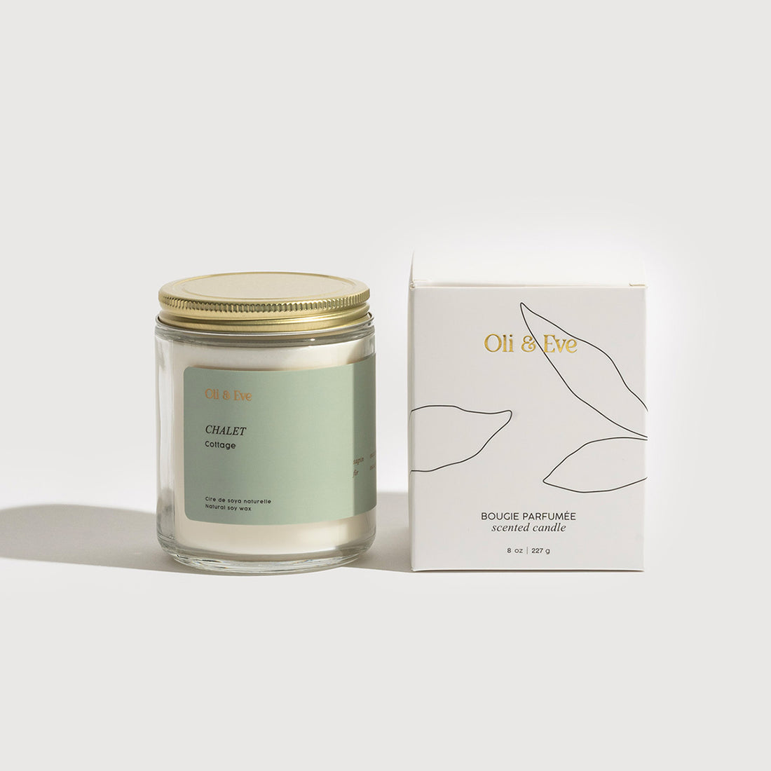 Candle with a gold lid and packaging box on a white background