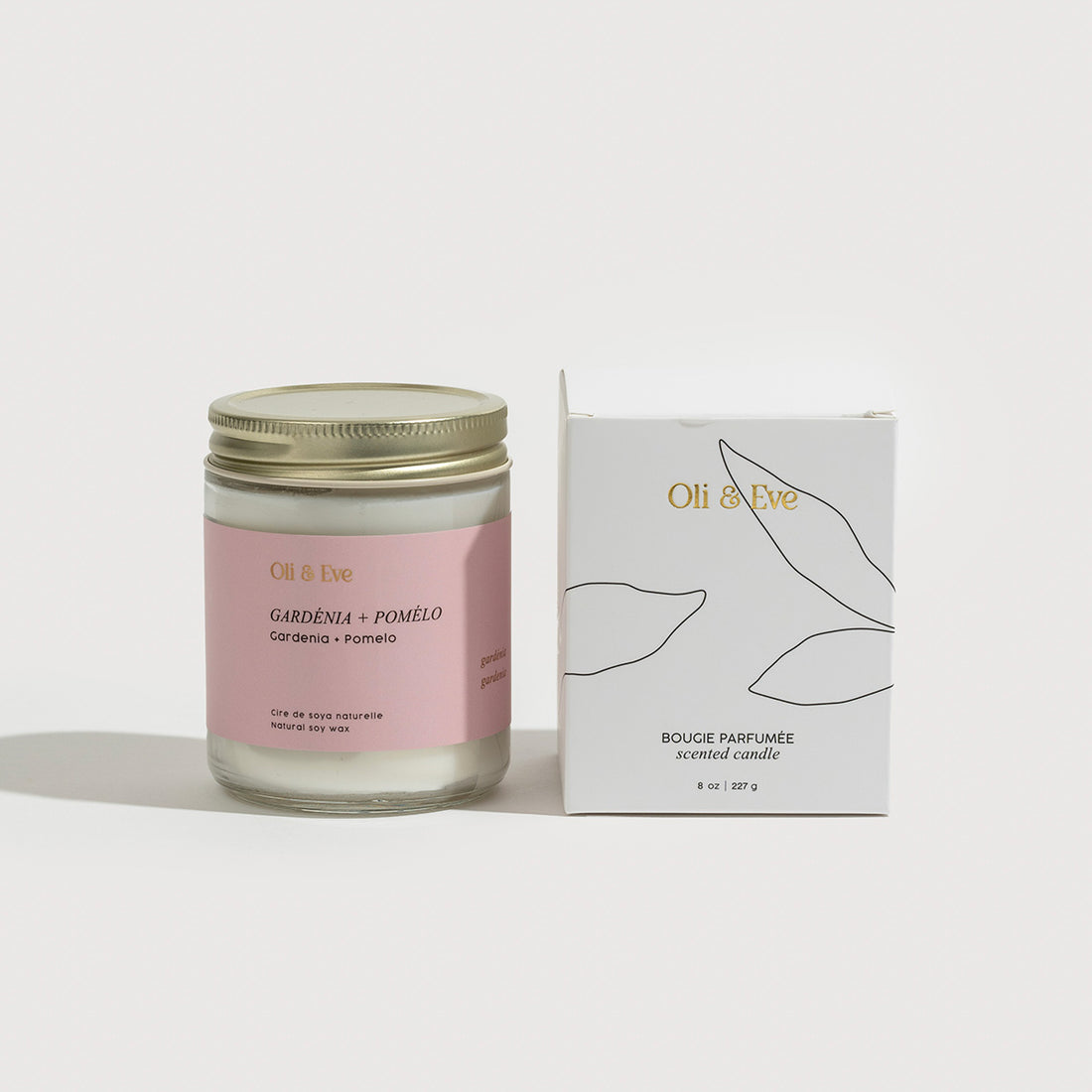 Oli &amp; Eve scented candle with pink label and matching box on a white background