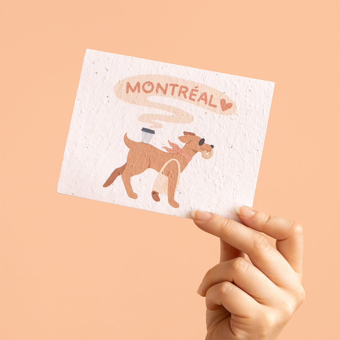 Hand holding a postcard with a dog illustration and &